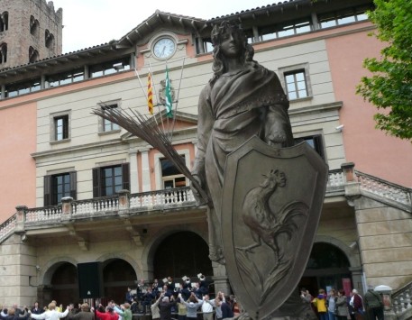  La dona, que representa la vila de Ripoll, sosté la palma del martiri i l'escut de Ripoll. Font: naciodigital.cat