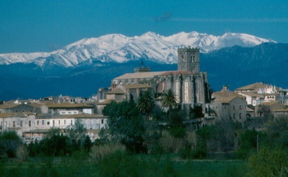 La Basílica de Santa Maria de Castelló d'Empúries amb el massís del Canigó al fons. Font: pinterest.com